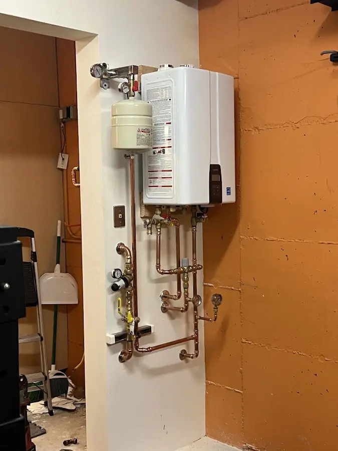 Plumbing technician inspecting water heater connections in Oshkosh